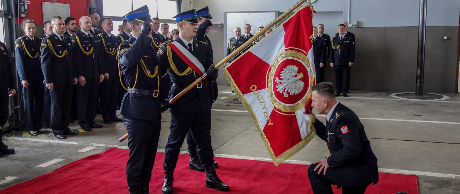 Pożegnanie st. bryg. Arkadiusza Margoszczyna ze sztandarem KM PSP w Opolu. W tle kadra KM PSP w Opolu oraz Komendanci Powiatowi z terenu województwa opolskiego.