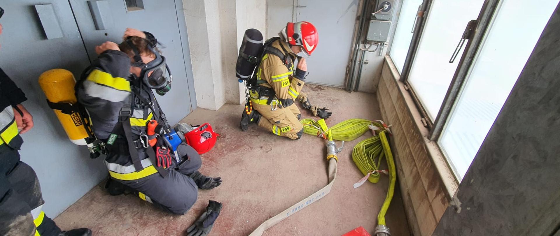 Widoczni strażacy podczas ćwiczeń z działań gaśniczych.