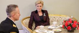 Na zdjęciu po lewej stronie znajduje się Komendant Główny PSP który rozmawia z Pierwszą Damą która siedzi po jego lewej stronie. 