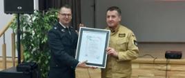 zdjęcie przedstawia Komendanta Miejskiego przyjmującego uroczysty dyplom