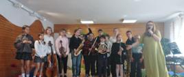 zdjęcie grupowe uczniów biorących udział w koncercie z nauczycielem prowadzącym