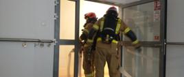 Strażacy docierają do zagrożonej części budynku i przygotowują się do prowadzenia działań ratowniczych oraz ewakuacji pacjentów. 