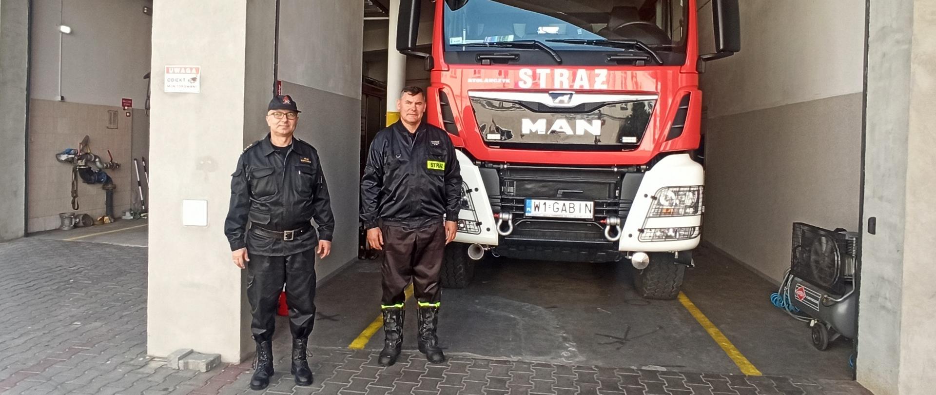 Na zdjęciu Komendant Miejski PSP w Płocku Adam Dobrosielski i druh Waldemar Zawadzki wspólnie pozujący do zdjęcia na tle samochodu Man.