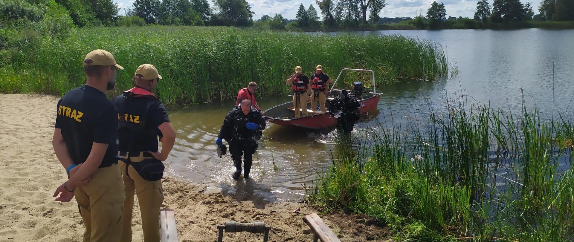 Strażacy wodują łódź na jeziorze