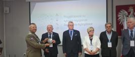 Wręczanie podziękowań w trakcie konferencji. Od lewej Generał Broni dr. Adam Joks Dowódca II-go Korpusu Polskiego, Dowódca Komponentu Lądowego, Podkarpacki Państwowy Wojewódzki Inspektor Sanitarny dr Adam Sidor, Wojewoda Podkarpacki Teresa Kubas-Hul, prof. dr hab. Krzysztof Kozak, prof. dr hab. inż. Paweł Olko 