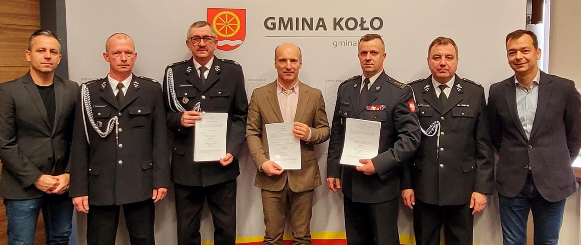 Zdjęcie przedstawia strażaków ochotników z jednostki OSP Powiercie, komendanta powiatowego PSP w Kole oraz wójta gminy Koło