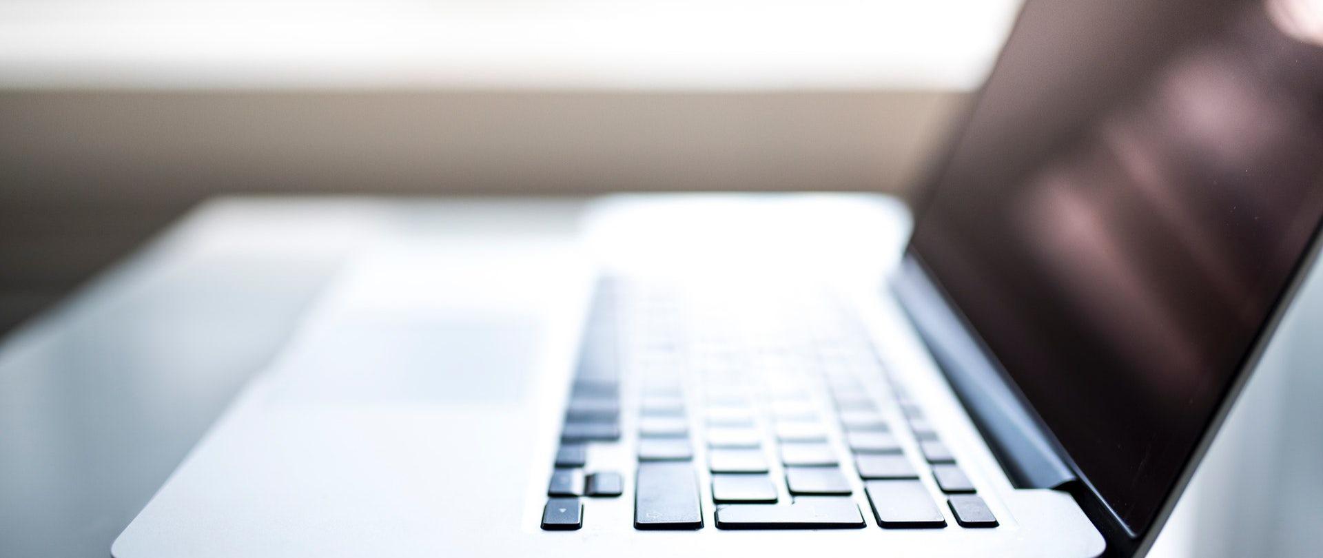 Komputer na stole, zbliżenie na krawędź laptopa.