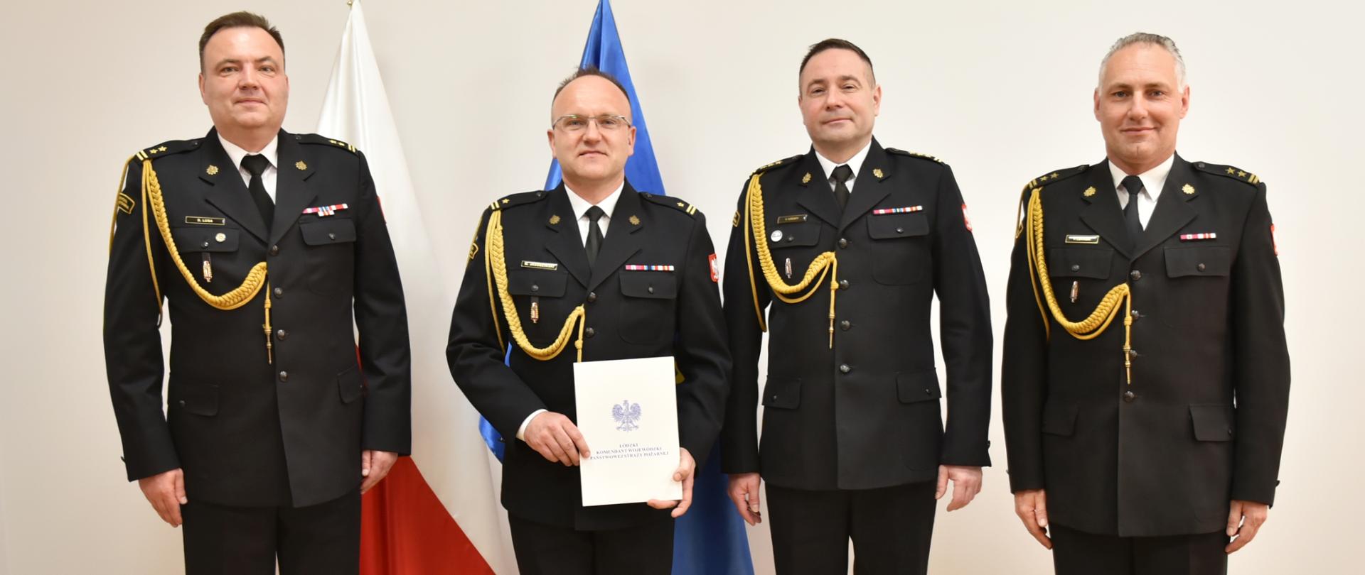 brygadier Lusa, młodszy brygadier Jagodziński starszy brygadier Kościsty oraz brygadier Łukasik pozują do zdjęcia na tle flag ue i polski