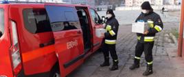 Strażacy wkładają środki ochrony indywidualnej do samochodu dostawczego