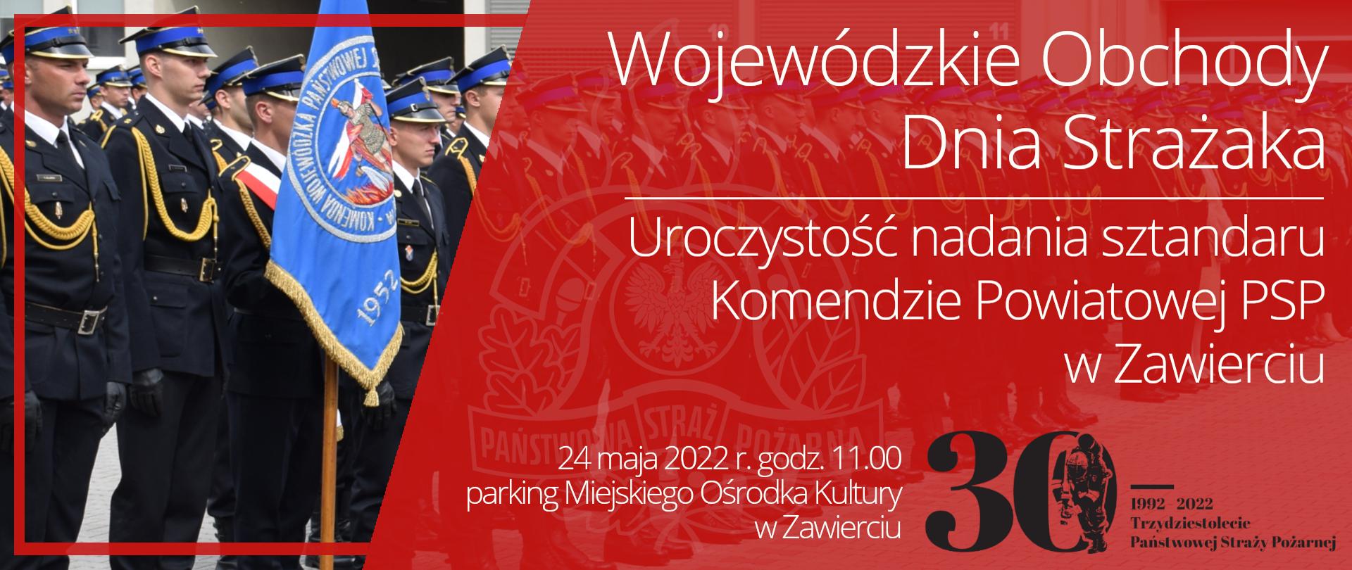 Na czerwonym tle z logo PSP napis Wojewódzkie Obchody Dnia Strażaka. Pod spodem napis "Uroczystość nadania sztandaru Komendzie Powiatowej PSP w Zawierciu 24 maja 2022r. godz. 11.00. parking Miejskiego Ośrodka Kultury w Zawierciu oraz czarne logo 30 lecia Państwowej Straży Pożarnej. Po prawej stronie widoczny fragment zdjęcia stojących w szeregu strażaków ze sztandarem. 