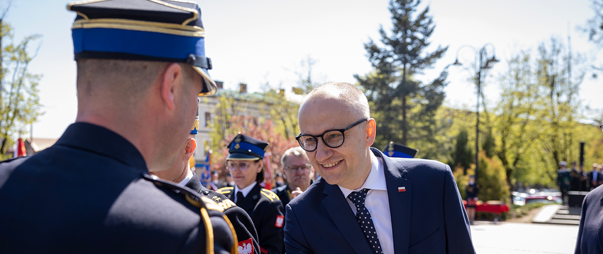 Wiceminister Błażej Poboży składa gratulacje odznaczonemu strażakowi