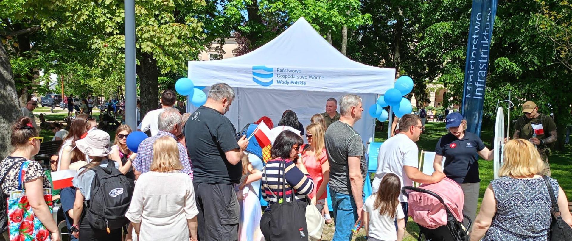 Grupa ludzi zgromadzonych przy stoisku PGW Wody Polskie 