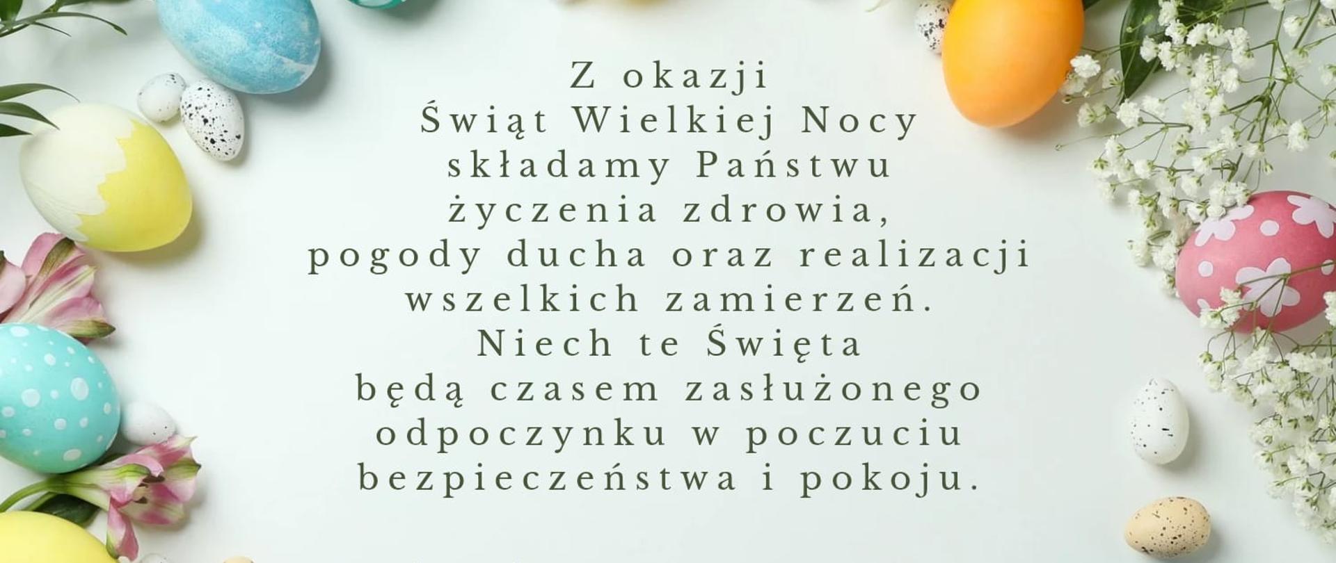 Wielkanocna karta z życzeniami na jasnym tle. W centrum znajduje się tekst: „Z okazji Świąt Wielkiej Nocy składamy Państwu życzenia zdrowia, pogody ducha oraz realizacji wszelkich zamierzeń. Niech te Święta będą czasem zasłużonego odpoczynku w poczuciu bezpieczeństwa i pokoju”. Brzegi grafiki zdobią pastelowe i wzorzyste pisanki oraz delikatne, białe i różowe kwiaty.