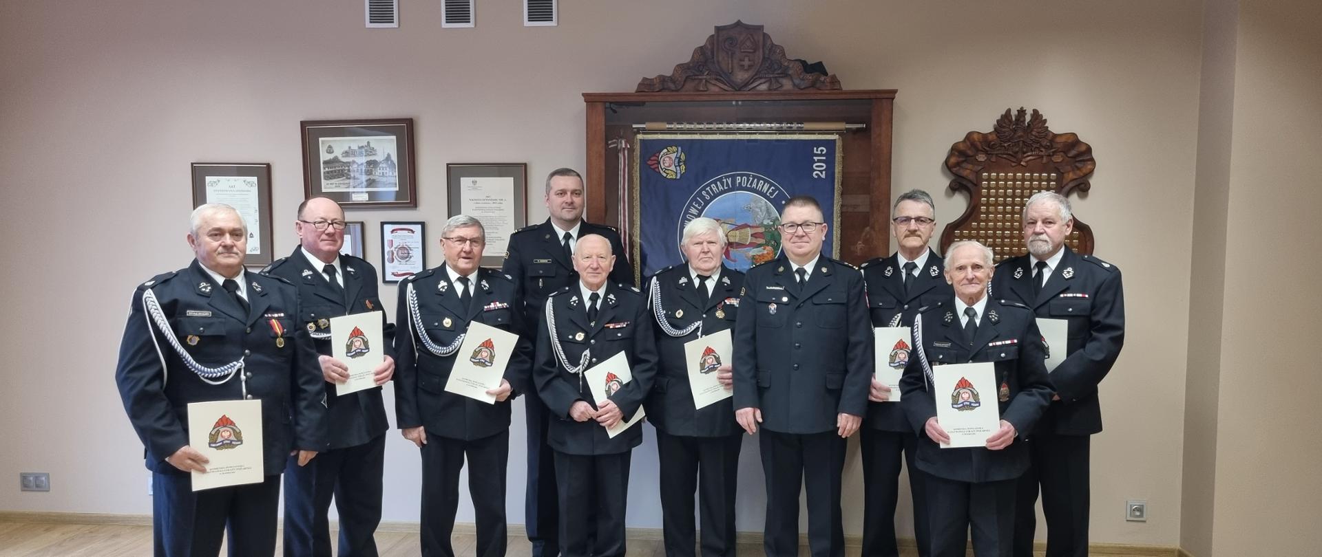 Komendant Powiatowy wraz z Zastępcą wręczają decyzje druhom OSP