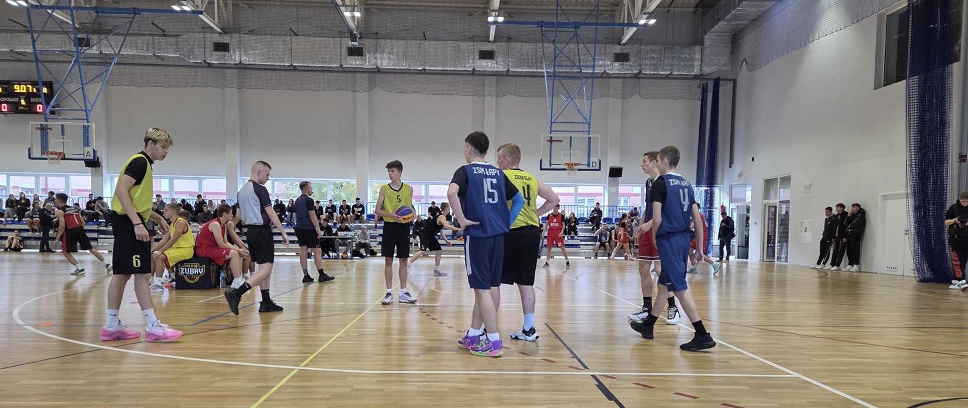 Młodzi zawodnicy podczas rozgrywek w hali sportowej