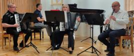 Zdjęcie przedstawia występ nauczycieli na scenie: Artur Niciejewski - akordeon, Daniel Rybak - fortepian, Ewa Rudzka-Sługocka - akordeon, Manfred Kudla - klarnet