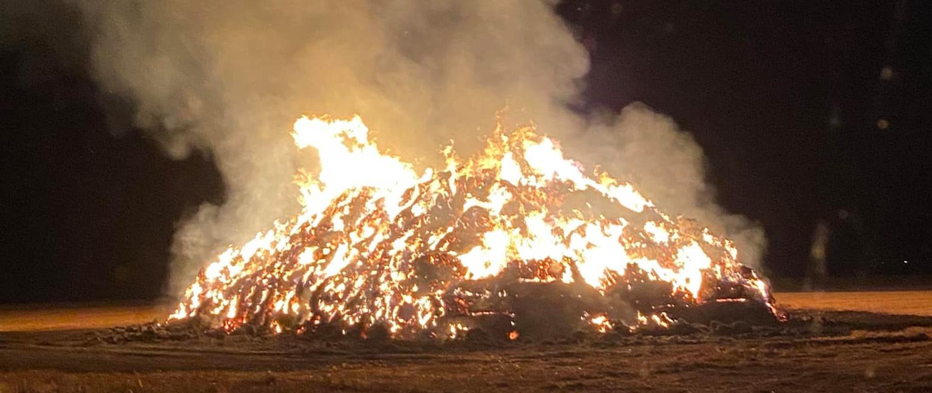 Widać stóg słomy który jest cały w ogniu