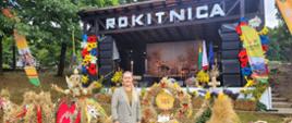 Kierownik Oddziału w Złotoryi stojąca na tle wieńców dożynkowych. Z tyłu znajduje się scena z dużym napisem Rokitnica