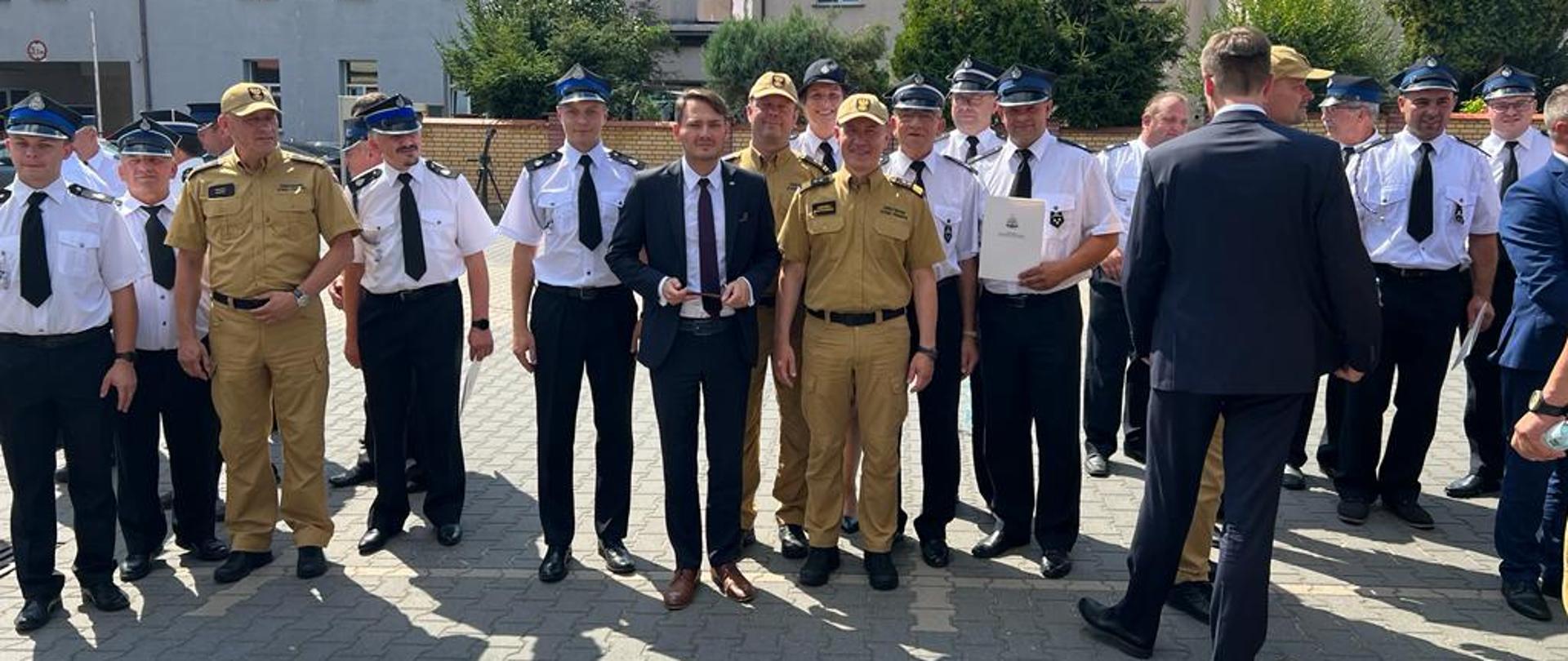 Uczestnicy uroczystości z ochotniczej straży pożarnej z Piątnicy z otrzymaną promesą w towarzystwie Komendanta Głównego PSP