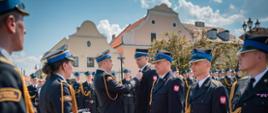 Zastępca komendanta głównego Państwowej Straży Pożarnej dekoruje strażaka w stopniu młodszego brygadiera.