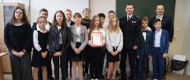 Dzieci z klasy laureatki wraz z Komendantem pozujące do zdjęcia