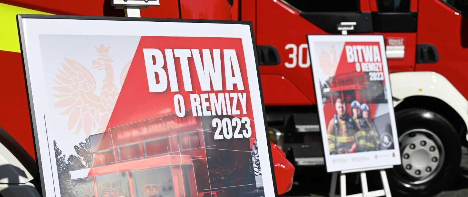 Dwa plakaty promocyjne akcji Bitwa o Remizy na tle dwóch pojazdów pożarniczych