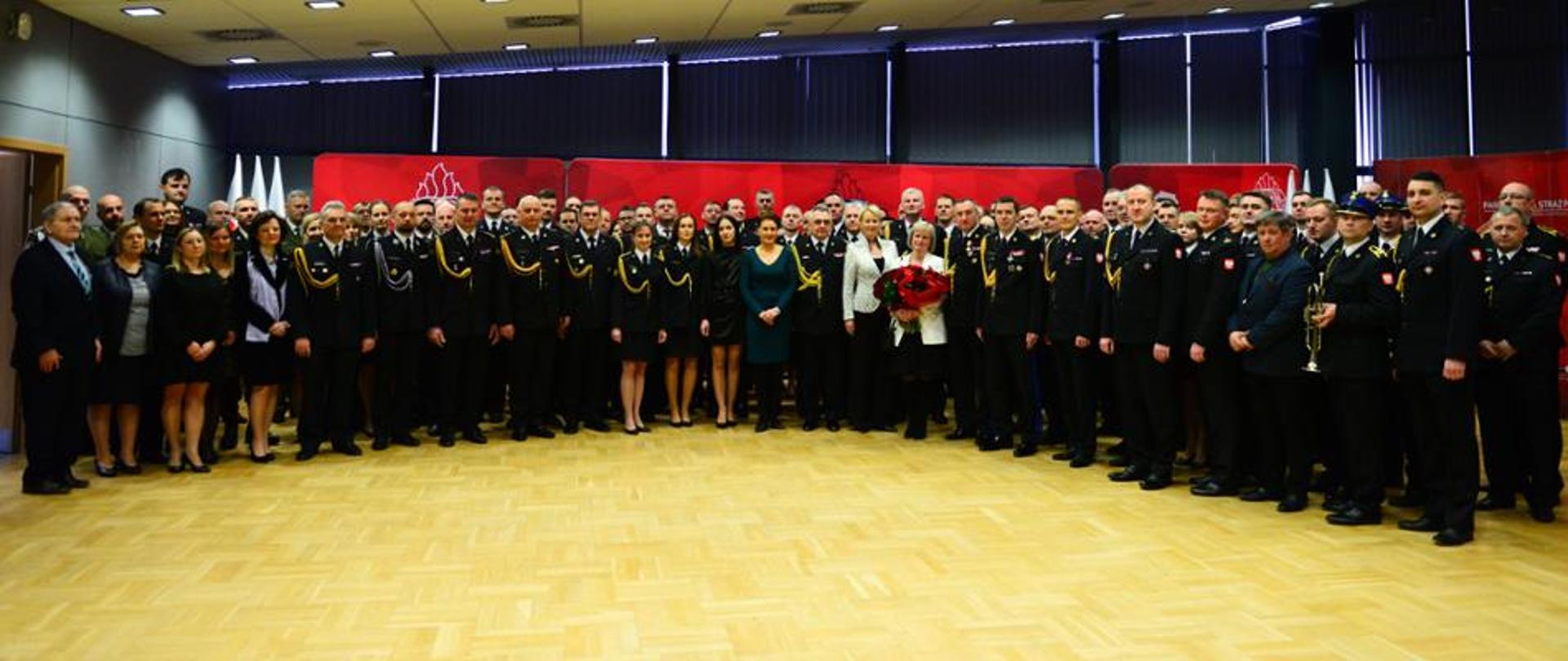 Strażacy, zaproszeni goście i inne osoby stoją wspólnie na zdjęciu