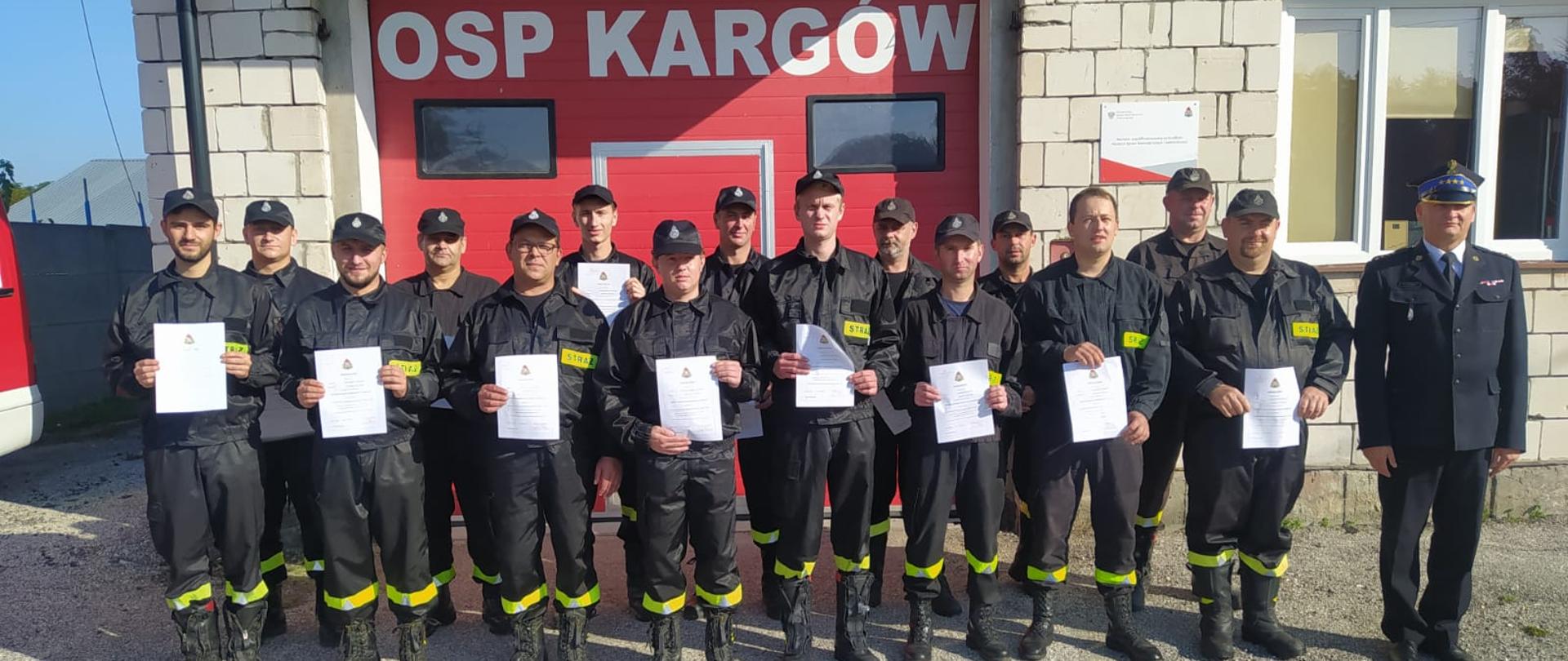Uczestnicy kursu z dyplomami na tle budynku OSP Kargów.