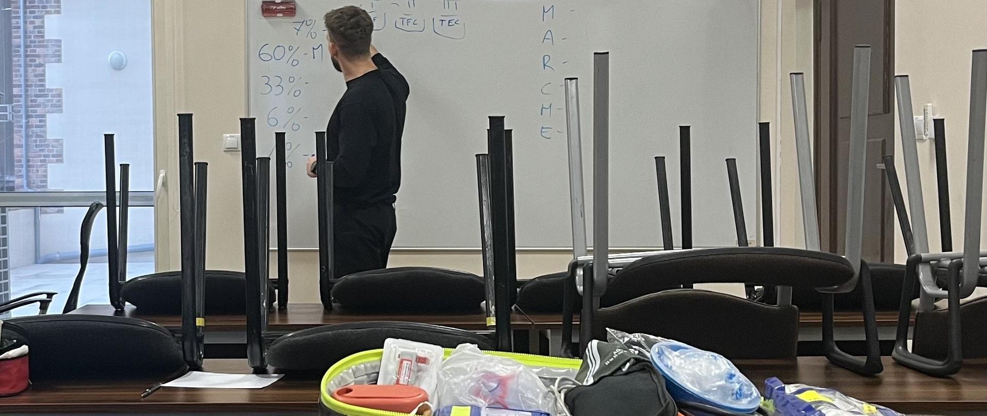 Prowadzący szkolenie przekazuje wiedzę teoretyczną na temat medycyny pola walki