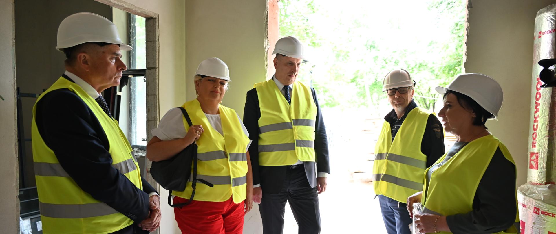 pięć osób stoi na tle dużego otworu w ścianie