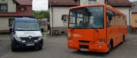 Od lewej strony: radiowóz ITD typu furgon i stojący obok niego autobus szkolny.