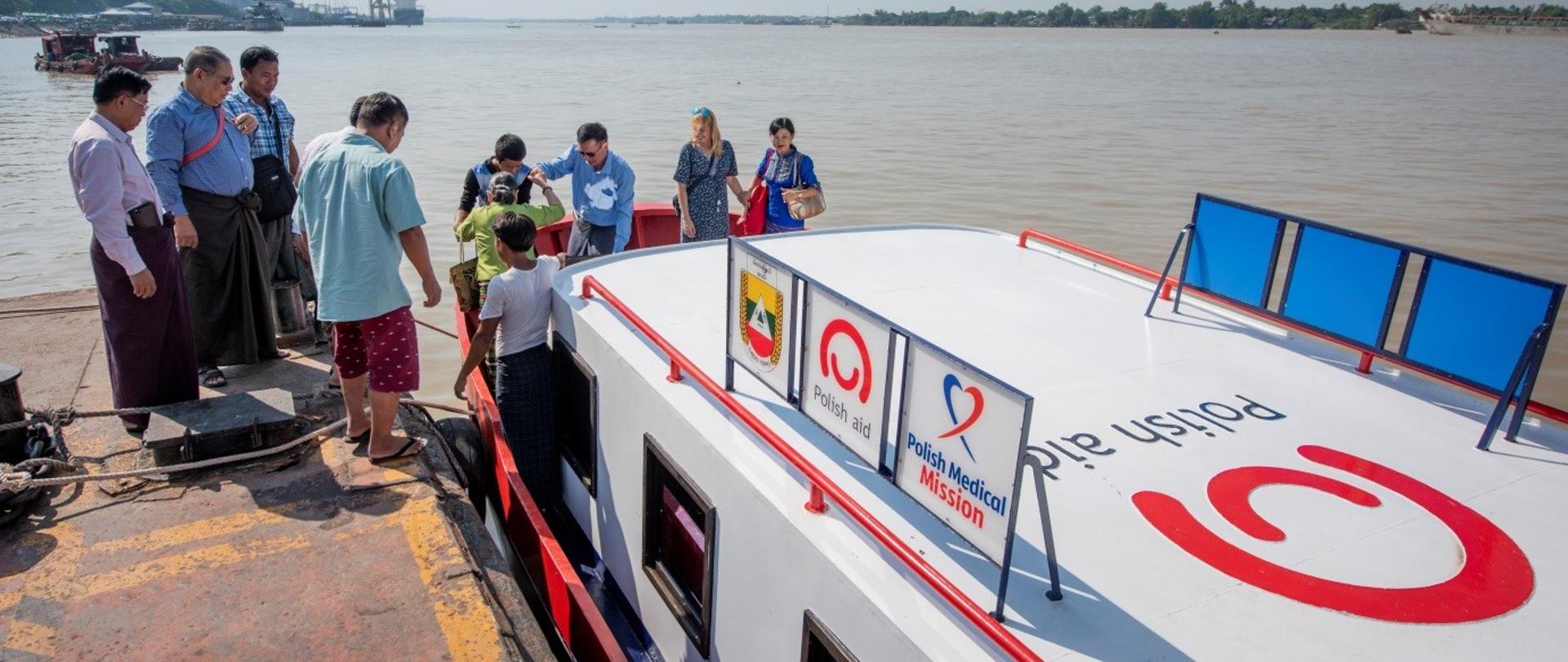 łódź z napisem na dachu Polish aid, na którą wsiadają pasażerowie