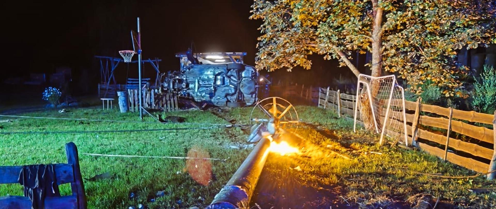 Pojazd na prawym boku w tle prywatnej posesji. Złamany słup energetyczny.
