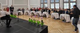 Grupa osób siedzących na krzesłach przy okrągłych stołach na koncercie podczas uroczystości wręczenia Medali za długoletnie pożycie małżeńskie - 06 października 2023
