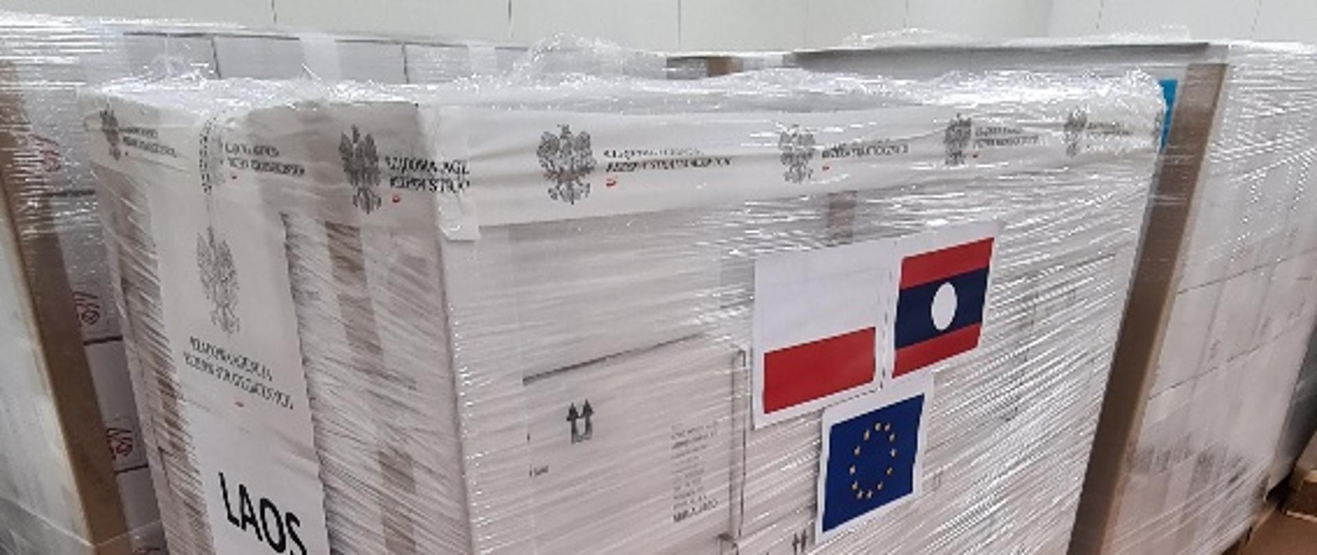 Zafoliowane paczki z naklejonymi flagami Polski, Laosu i Unii Europejskiej
