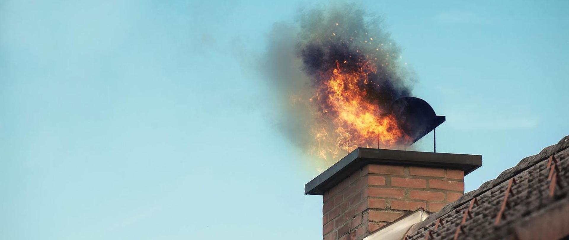 Płomienie wydostające się z przewodu kominowego objętego pożarem.