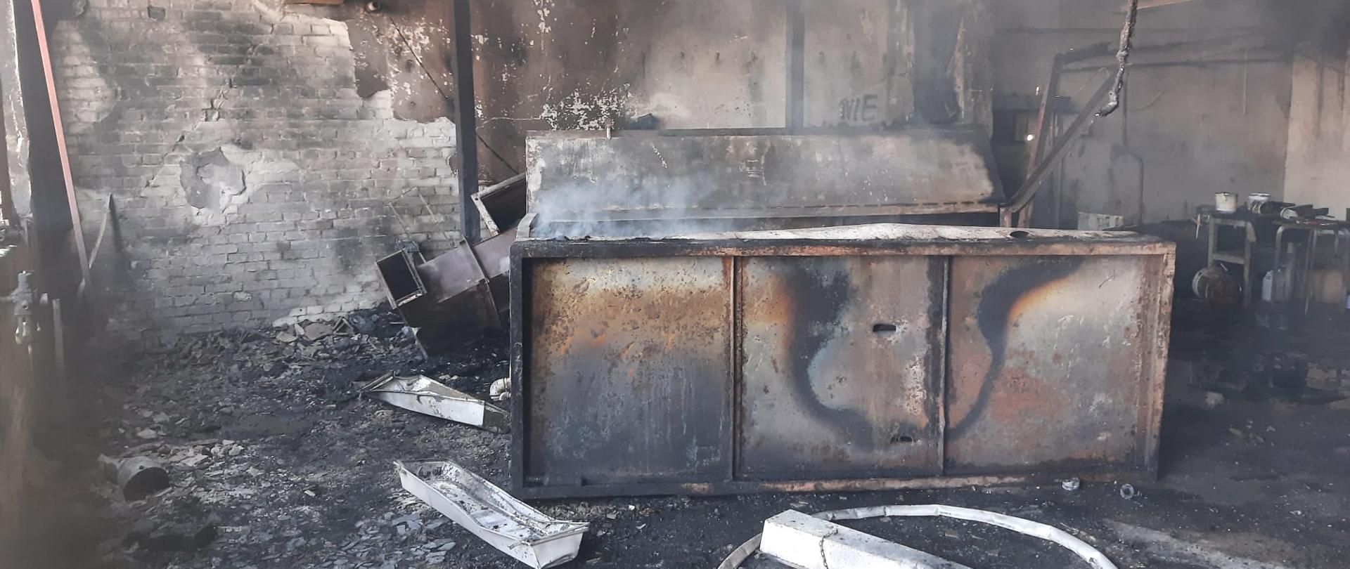Okopcone wnętrze i spalone wyposażenie pomieszczenia, w którym doszło do pożaru.