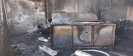 Okopcone wnętrze i spalone wyposażenie pomieszczenia, w którym doszło do pożaru.