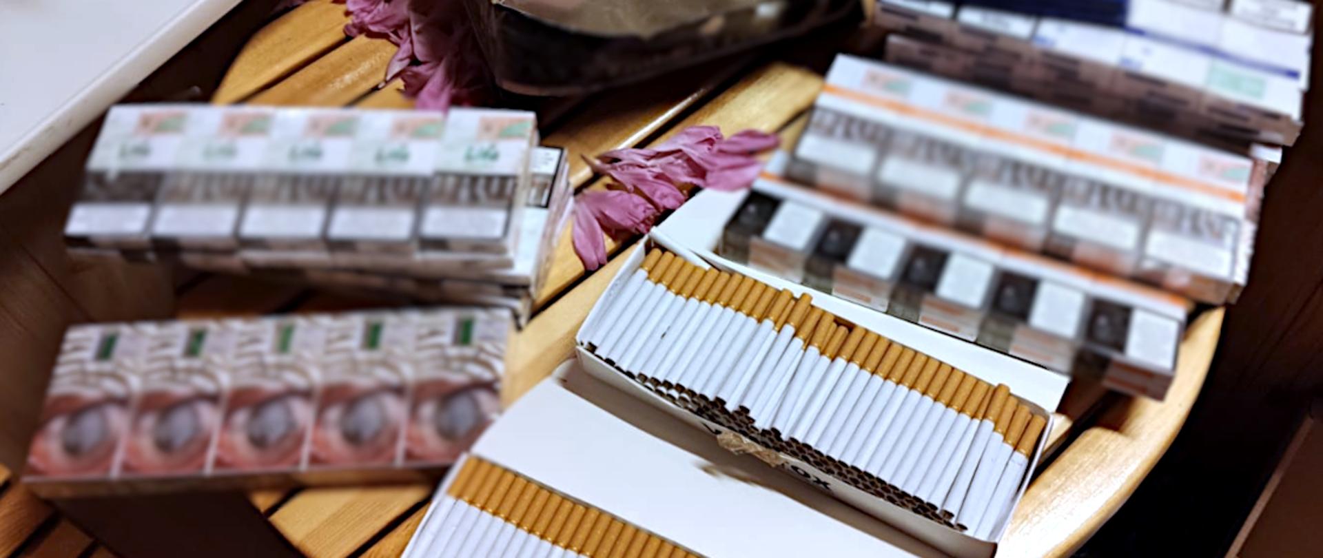 Papierosy i paczki z papierosami na stole.