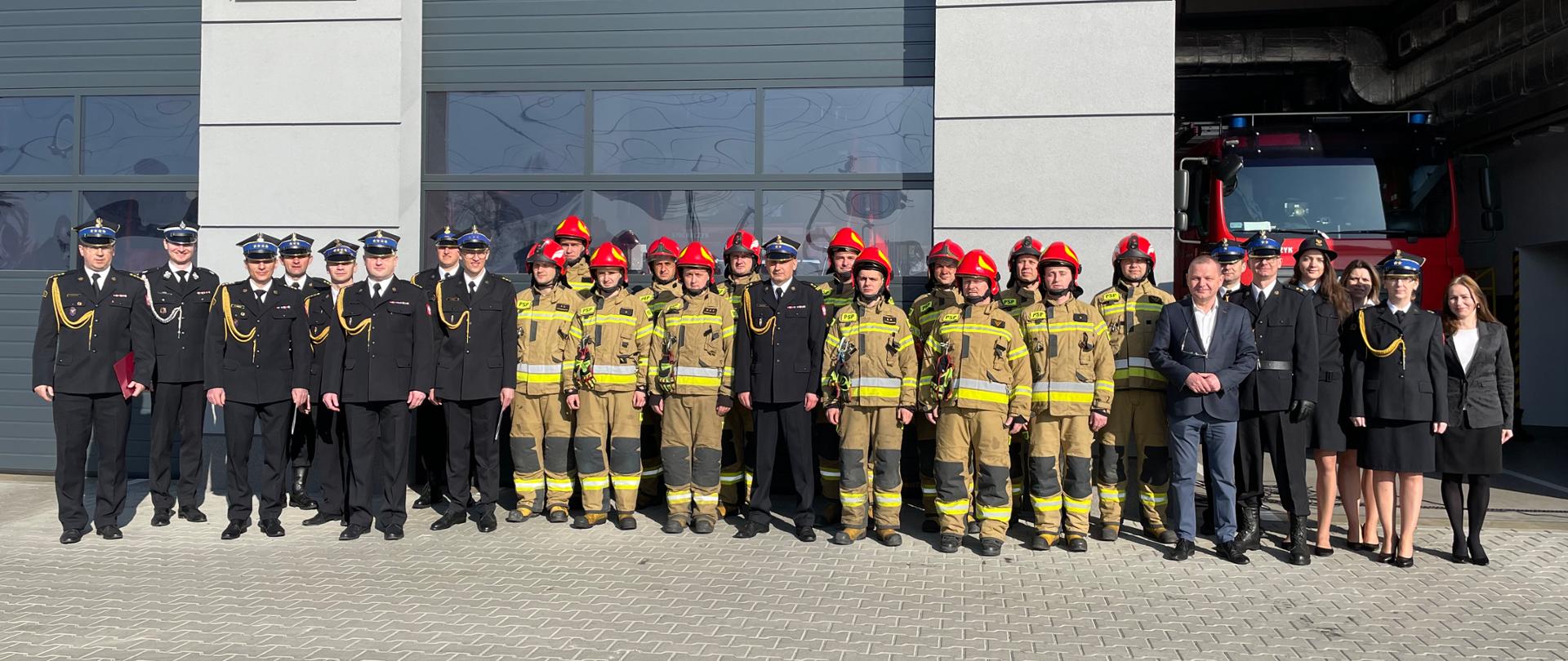 Na zdjęciu strażacy przed garażem