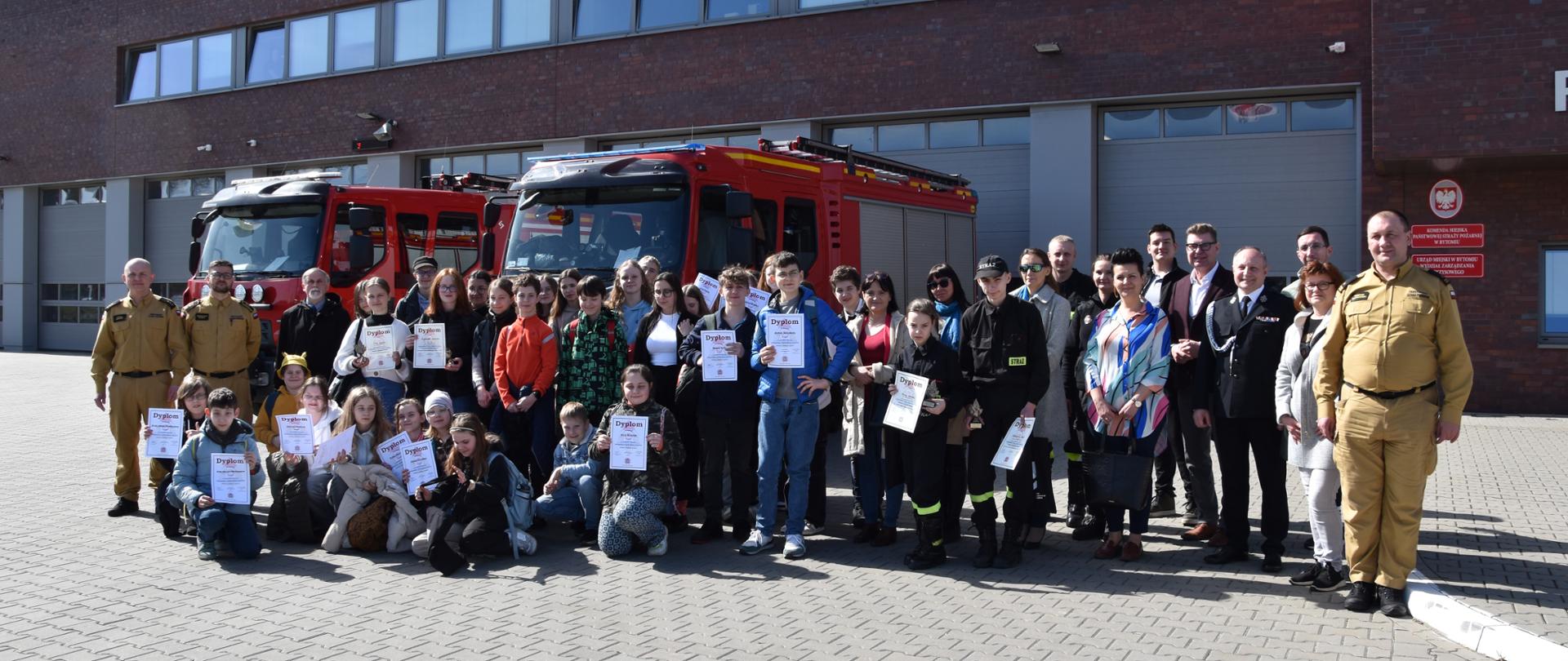 Uczestnicy eliminacji zebrani przy wozach bojowych przed budynkiem bytomskiej straży 