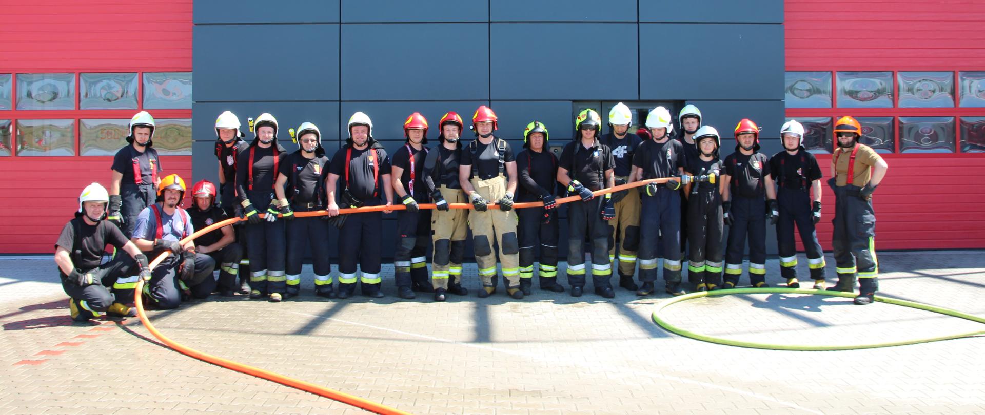 zdjęcie przedstawia grupę strażaków podczas pozowania do wspólnego zdjęcia
