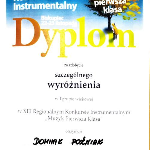 Dyplom konkursowy ucznia szkoły muzycznej w kolorze białym, nagłówek w kolorze niebieskim. Po prawej stronie u góry grafika jesiennego drzewa z opadającymi liśćmi.