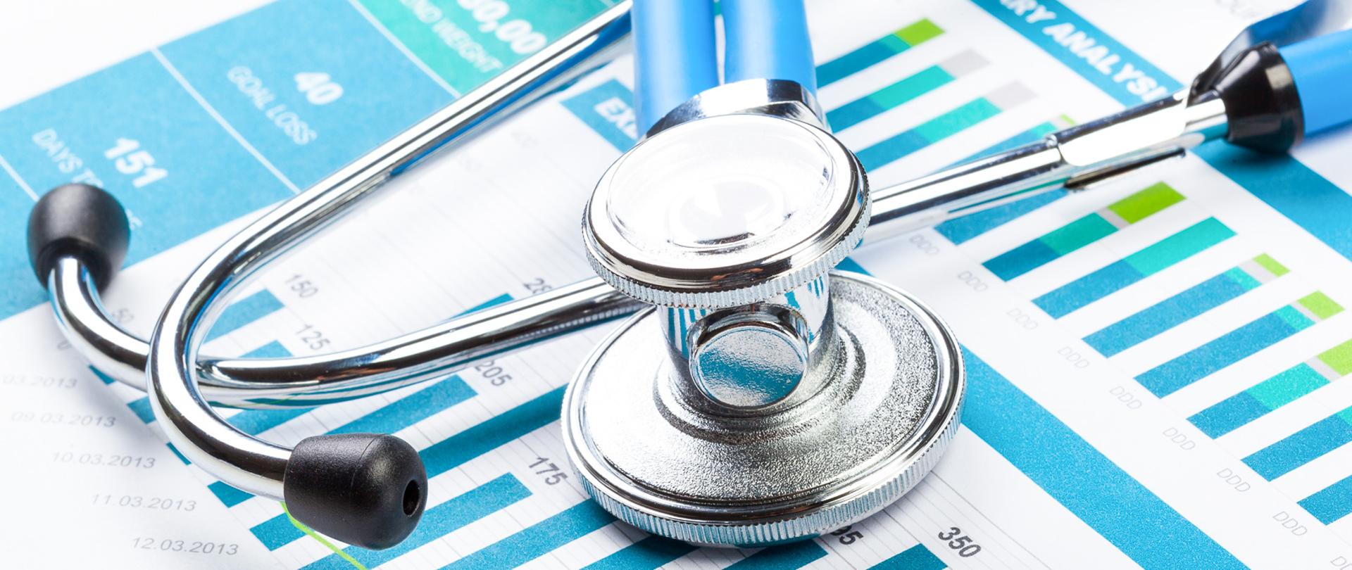 Stethoscope with financial on the desk.