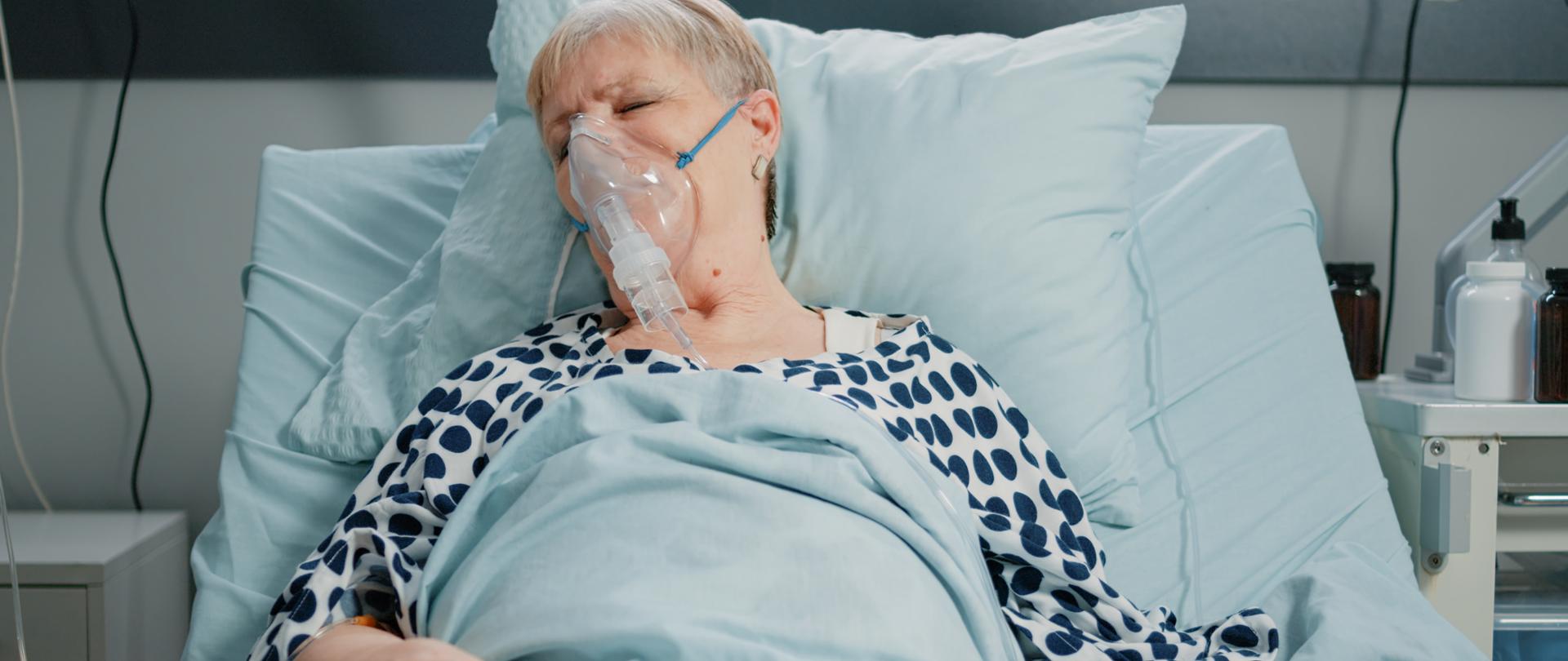 starsza kobieta leży w szpitalu pod aparaturą