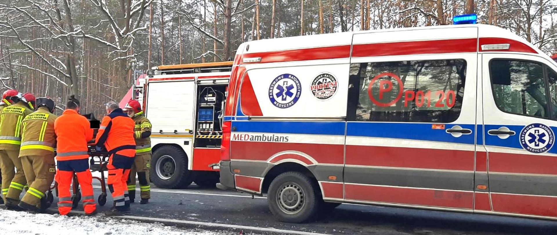 Na zdjęciu znajduje się pojazd pogotowia ratunkowego oraz ratownicy.