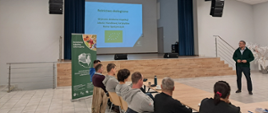 sala szkoleniowa, słuchacze siedzą na krzesłach, Inspektor IJHARS jako prowadzący, w tle prezentacja 