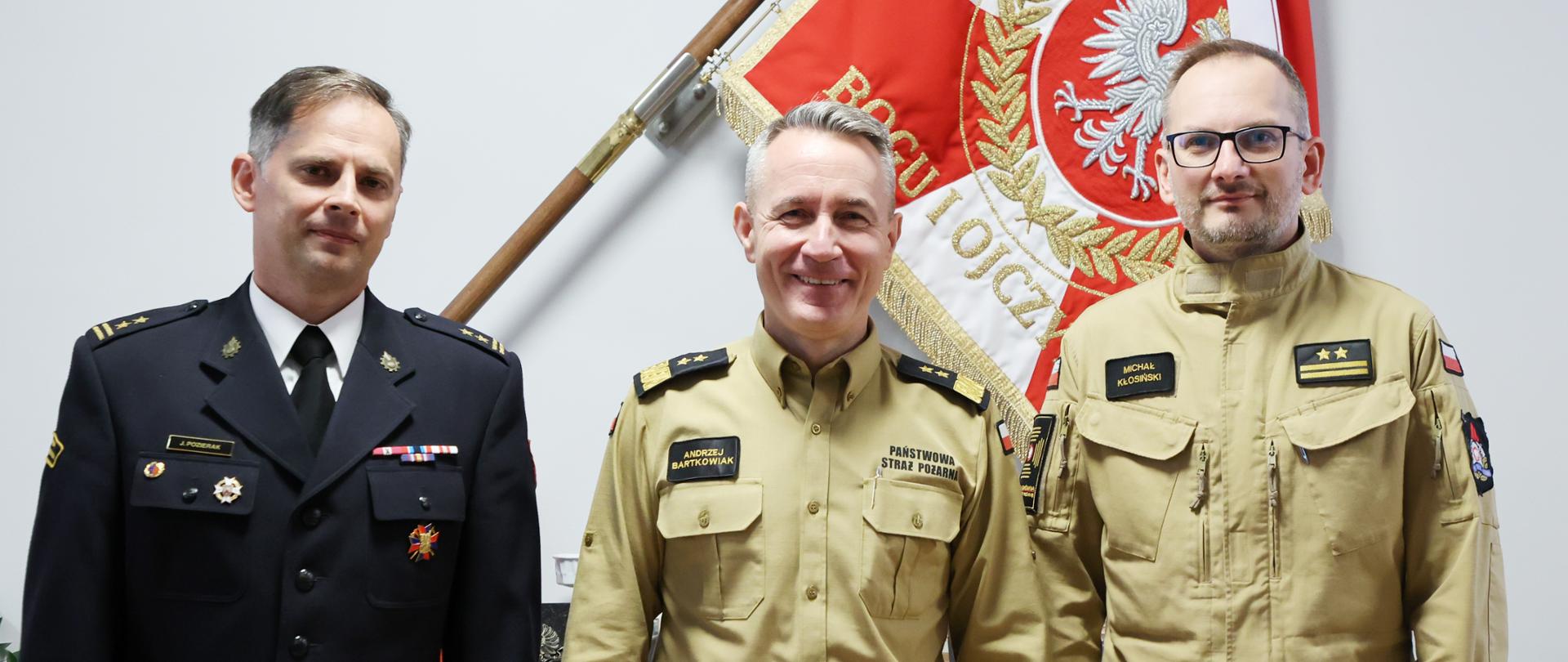 Zdjęcie pamiątkowe (od lewej) nowy dyrektor Biura Bezpieczeństwa Informacji, komendant główny PSP oraz zastępca dyrektora BBI. W tle sztandar Komendy Głównej Państwowej Straży Pożarnej