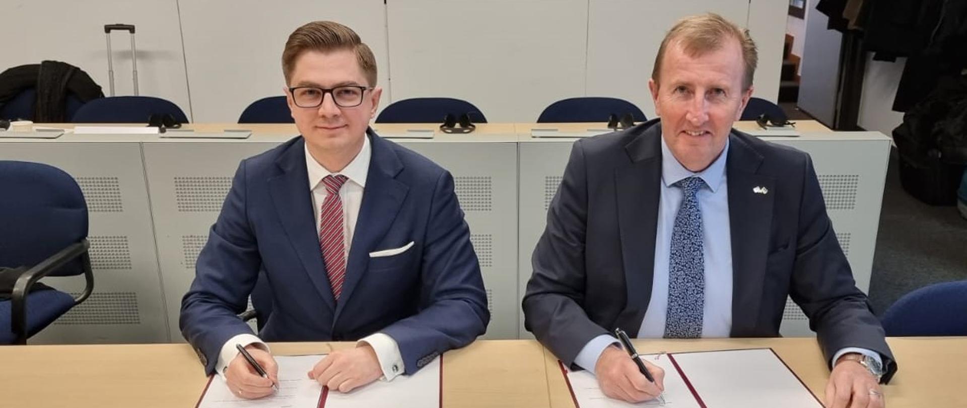 Prezes PAA dr Łukasz Młynarkiewicz oraz Mark Foy, Główny Inspektor ds. Jądrowych Wielkiej Brytanii podpisują porozumienie o współpracy