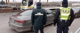 Funkcjonariusz KAS i policjant przy samochodzie osobowym